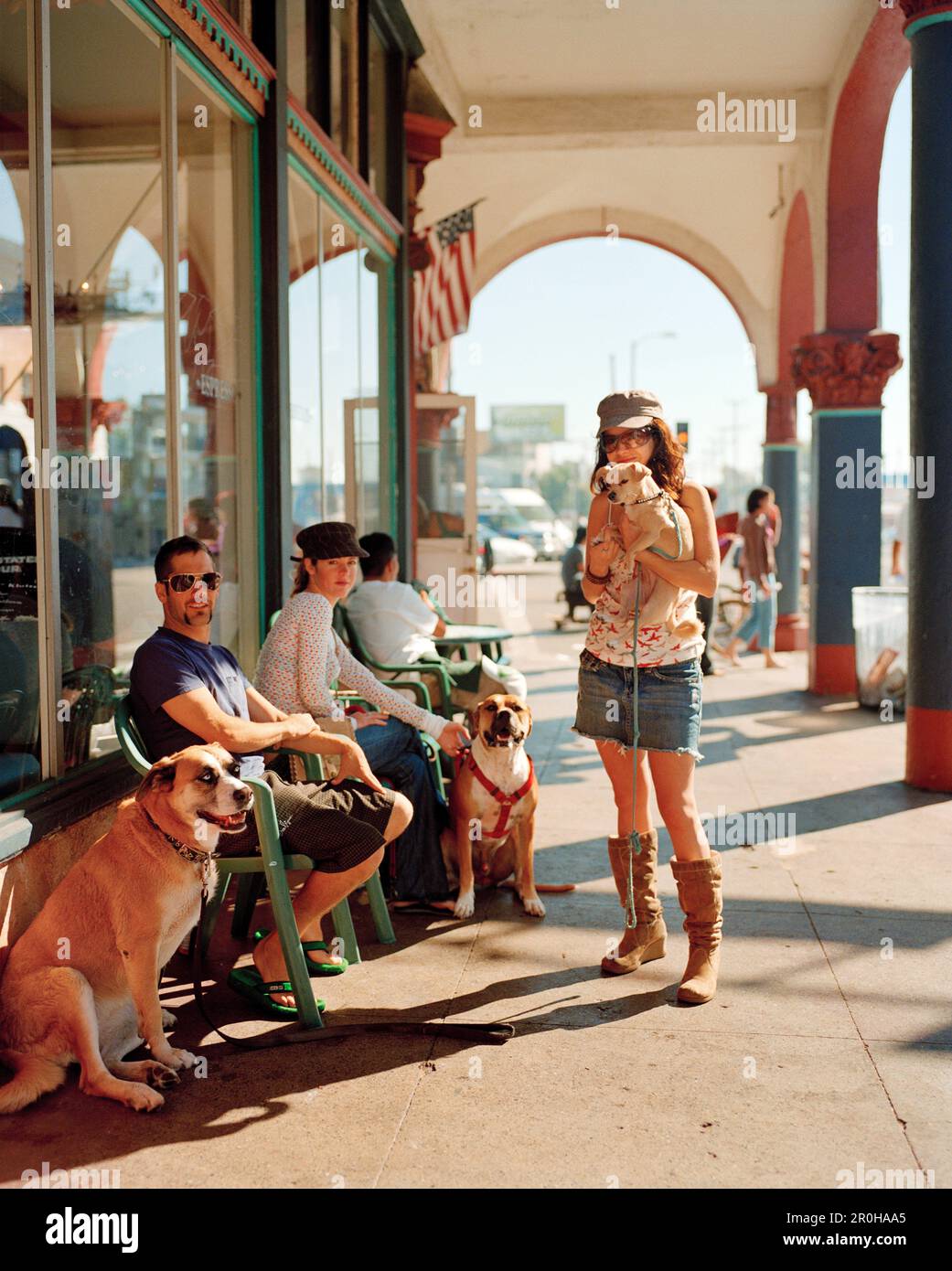 USA, California, Venice Beach, Los Angeles, una giovane donna e i suoi amici si riuniscono di fronte al Cafe Collage all'angolo tra Pacific Avenue e Wind Foto Stock