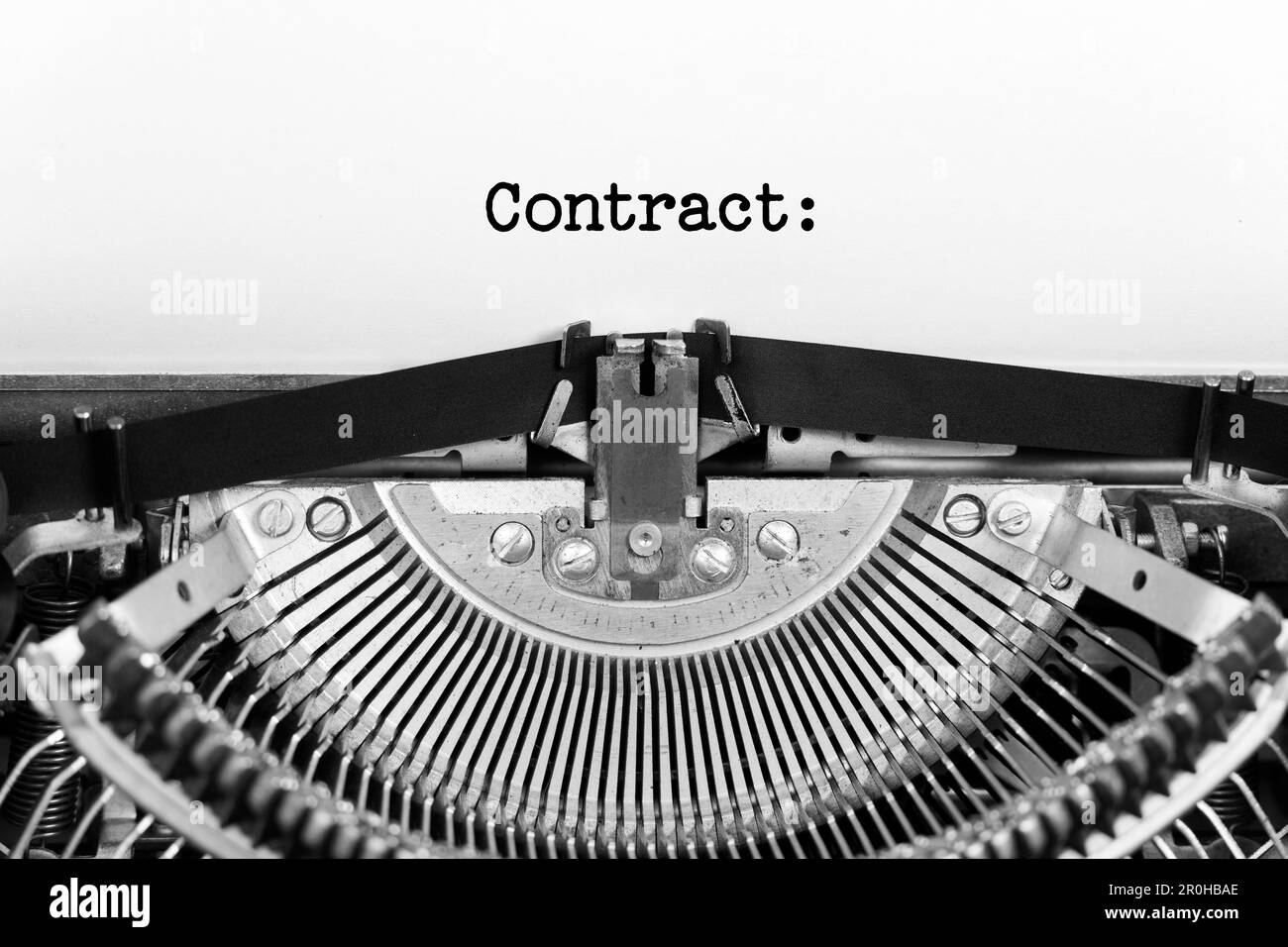 Closeup parola del contratto che sta digitando e centrato su un foglio di carta su vecchia macchina da scrivere d'annata meccanica Foto Stock