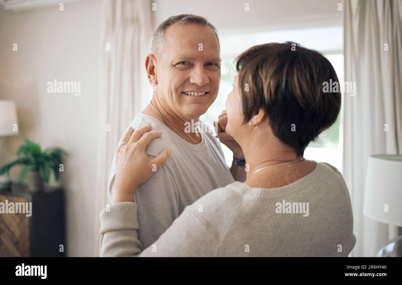 Ancora giri il mio mondo intorno. una coppia matura che ballava lentamente nel loro salotto. Foto Stock