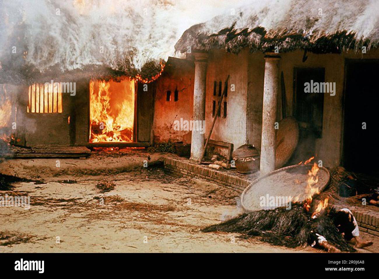 Cadaveri fuori da una casa in fiamme nel villaggio vietnamita di My Lai dopo che circa 500 civili furono massacrati dalle truppe americane durante la guerra del Vietnam. Foto Stock