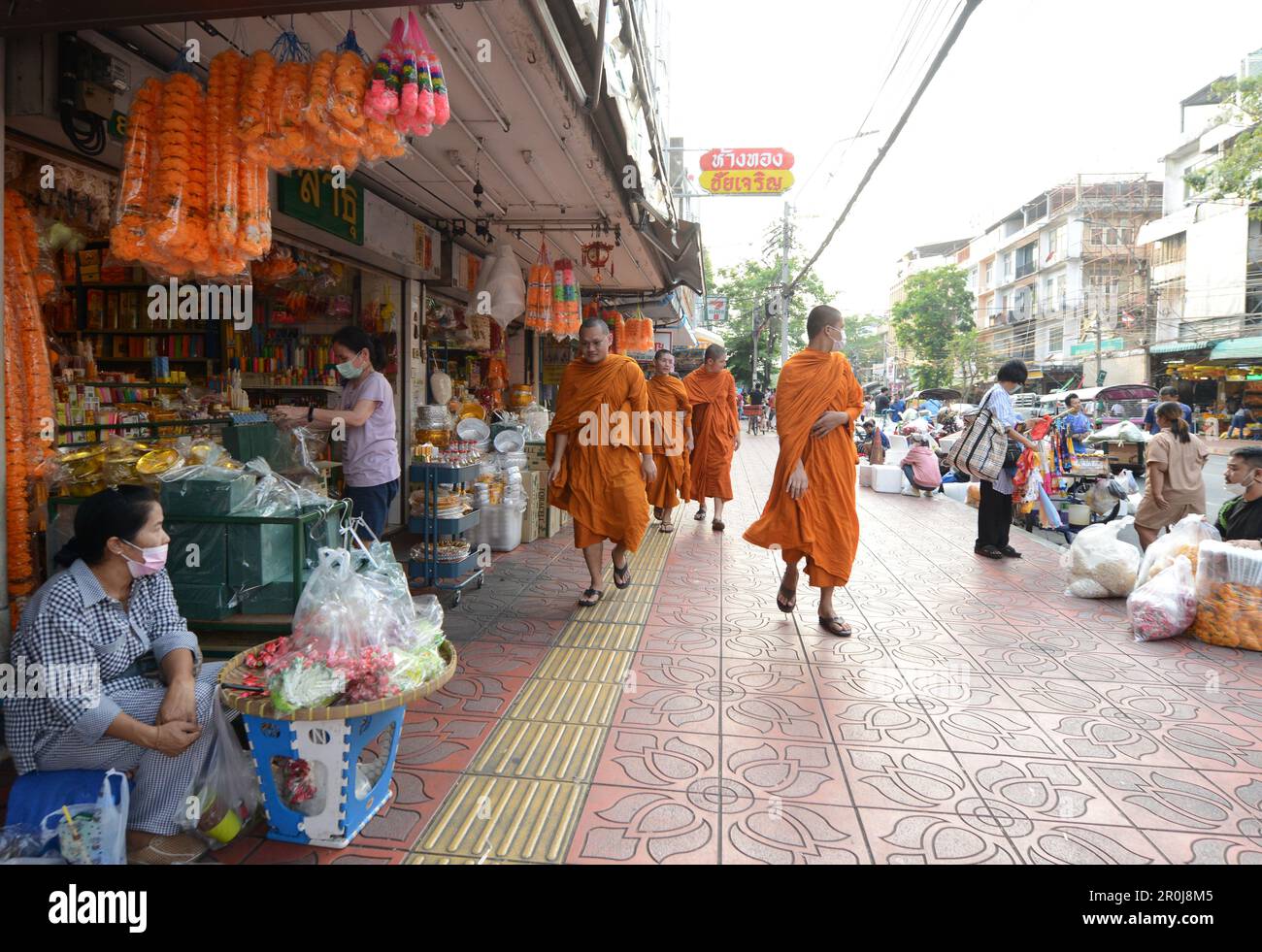 Monaci buddisti thailandesi che camminano al colorato Pak Khlong Talat (mercato dei fiori) a Bangkok, Thailandia. Foto Stock