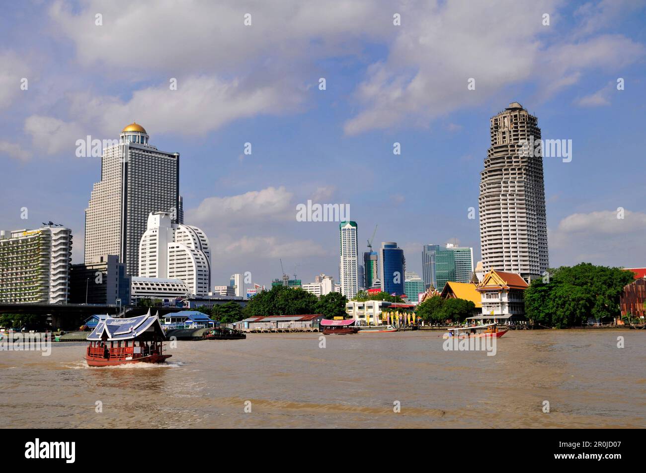 Una vista del fiume Chao Phraya con la Torre fantasma di Sathorn e la Torre di Stato vicino a Silom Road. Bangkok, Thailandia. Foto Stock