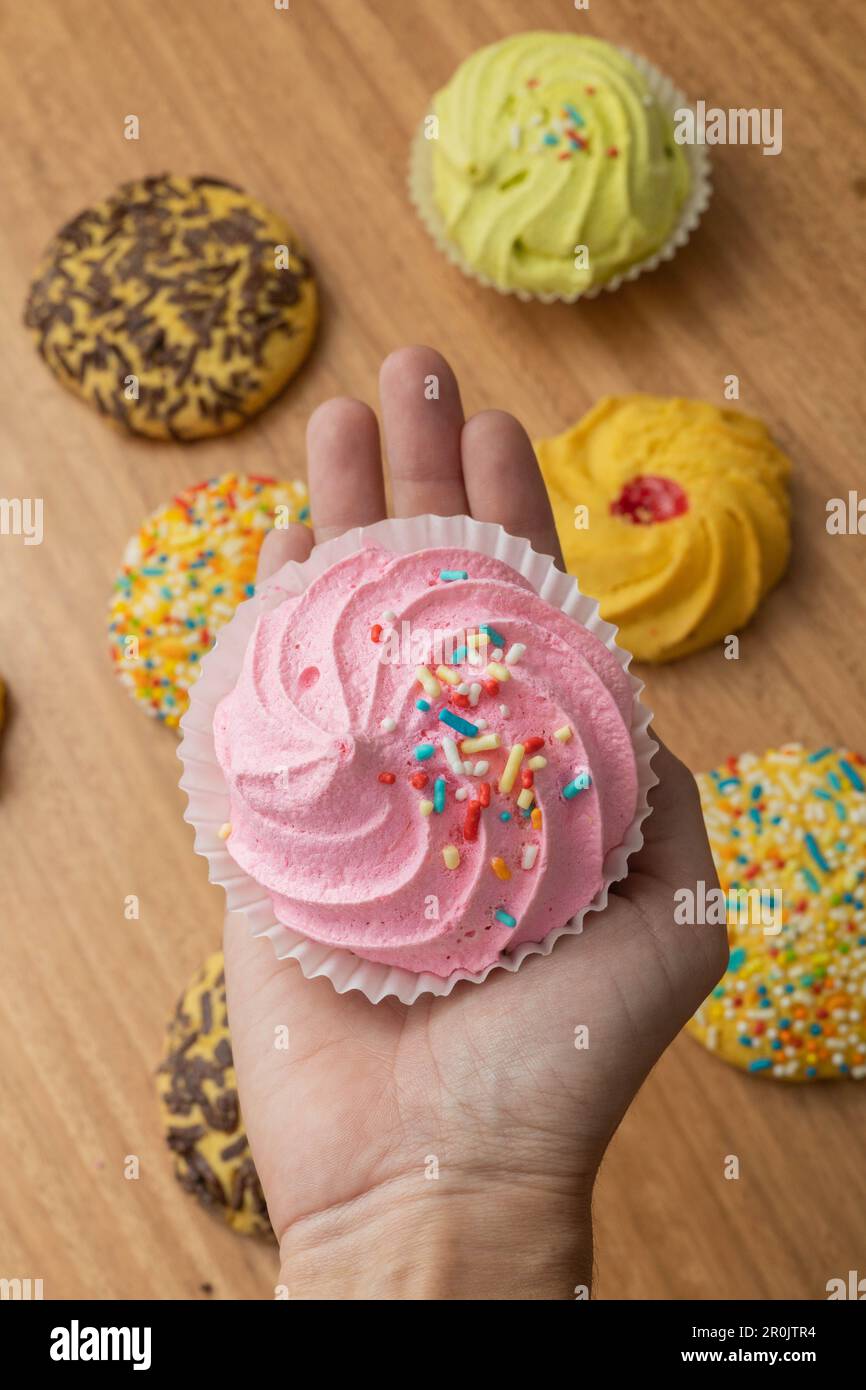 prodotti di pasticceria, tenendo un delizioso tradizionale dolcetto colorato, sullo sfondo molti biscotti con draghi, bei dessert come carta da parati Foto Stock