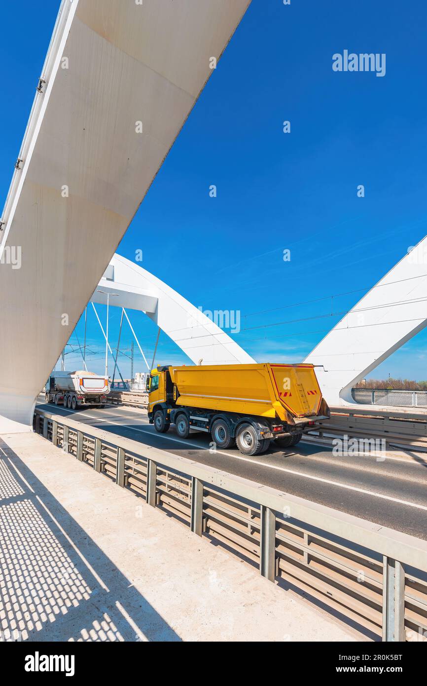 Autocarro con semirimorchio ribaltabile che attraversa il ponte, messa a fuoco selettiva Foto Stock