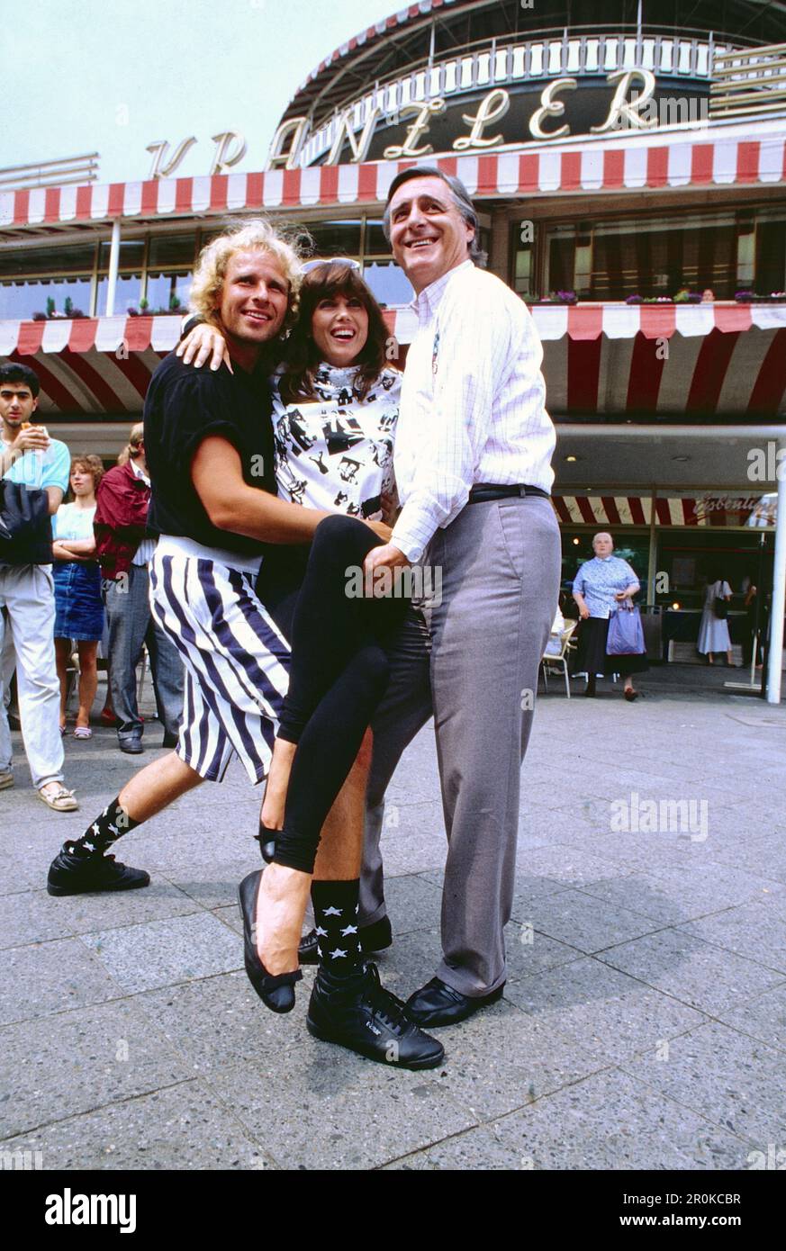 Amerikanische Schauspielerin Deborah Shelton zwischen Thomas Gottschalk und Helmut Fischer bei Dreharbeiten zum Film: Zärtliche Chaoten 2, vor dem Cafe Kranzler a Berlino, Deutschland um 1988. Foto Stock