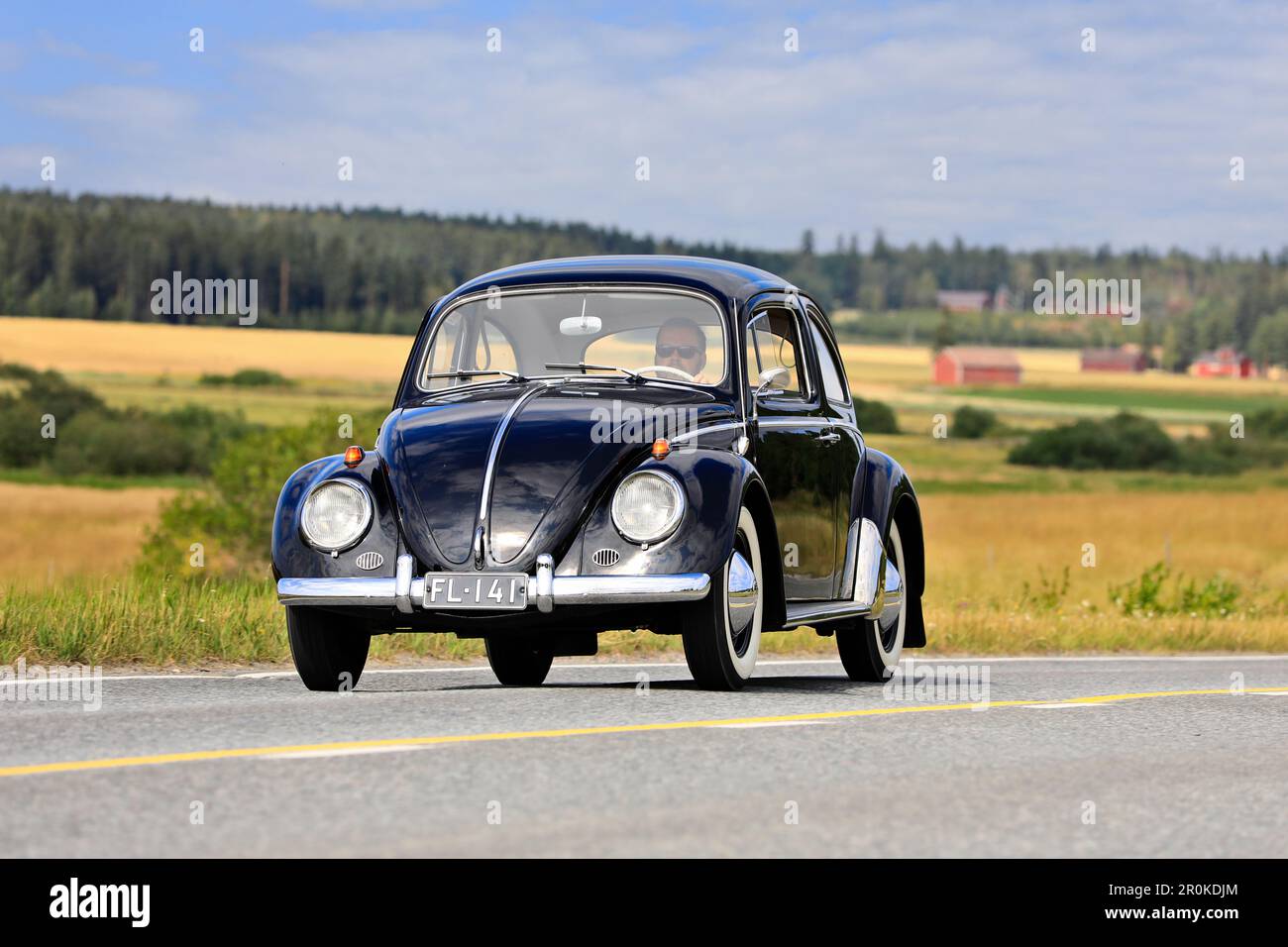 Nero Volkswagen Beetle, ufficialmente Volkswagen tipo 1, guida lungo la strada di campagna su Maisemaruise 2019 auto crociera. Vaulammi, Finlandia. Agosto 3, 2019. Foto Stock