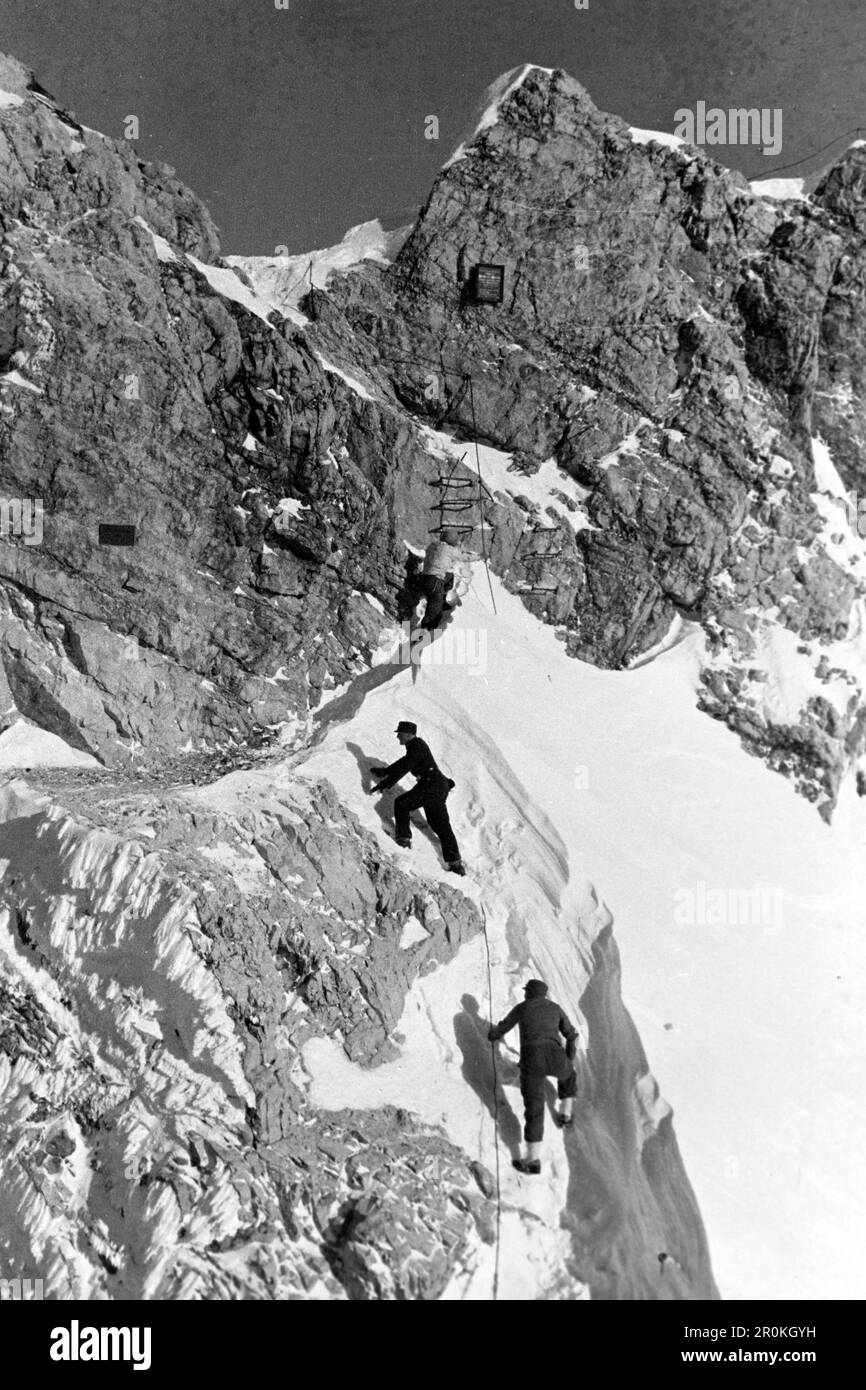 Drei Menschen erklimmen den Gipfel des Kreuzeck, Kreuzeck 1936.tre persone salgono alla cima del Kreuzeck, Kreuzeck 1936. Foto Stock