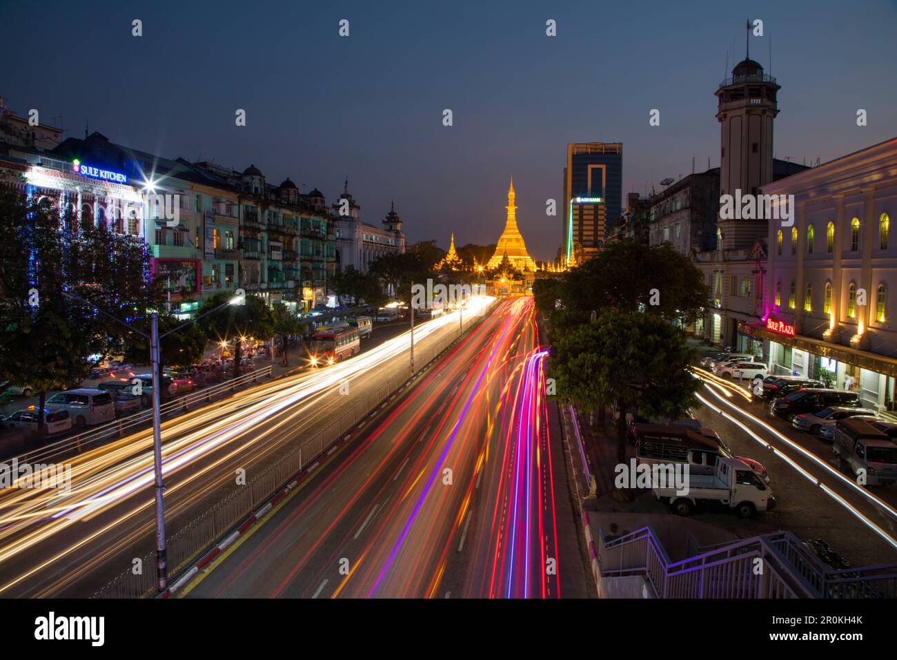 Strisce di luci auto su Sule Pagoda Road e illuminato Sule Pagoda al crepuscolo, Yangon, Yangon, Myanmar Foto Stock