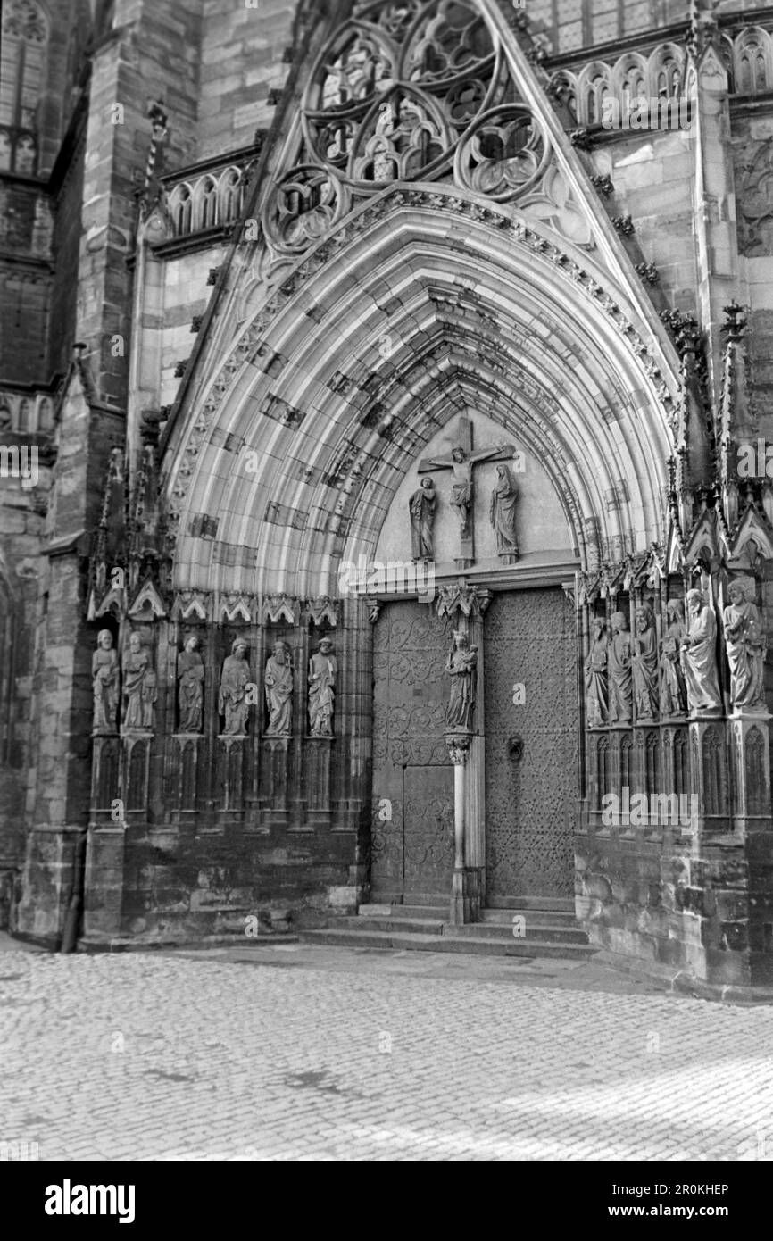 Eine der Türen des Triangel-Portalvorbaus des Erfurter Doms mit den zwölf Aposteln, der heiligen Jungfrau Maria mit Jesuskind und Jesus am Kreuz mit Maria und Johannes, 1956. Una delle porte del portico triangolare della Cattedrale di Erfurt con i dodici apostoli, la Beata Vergine Maria con Gesù Bambino e Gesù sulla croce con Maria e Giovanni ai suoi lati, 1956. Foto Stock