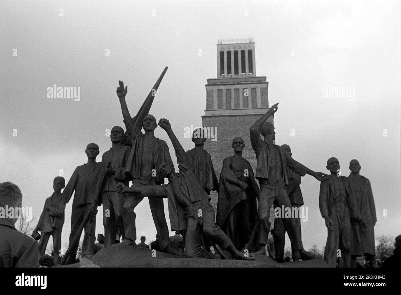 Von Fritz Cremer und Bertolt Brecht gestaltetes Denkmal zu Ehren des Widerstandskampfes im KZ Buchenwald mit dem Turm der Freiheit im Hintergrund, Gedenkstätte Buchenwald 1960. Monumento progettato da Fritz Cremer e Bertolt Brecht in onore della lotta di resistenza nel campo di concentramento di Buchenwald con la Torre della libertà sullo sfondo, Buchenwald Memorial 1960. Foto Stock