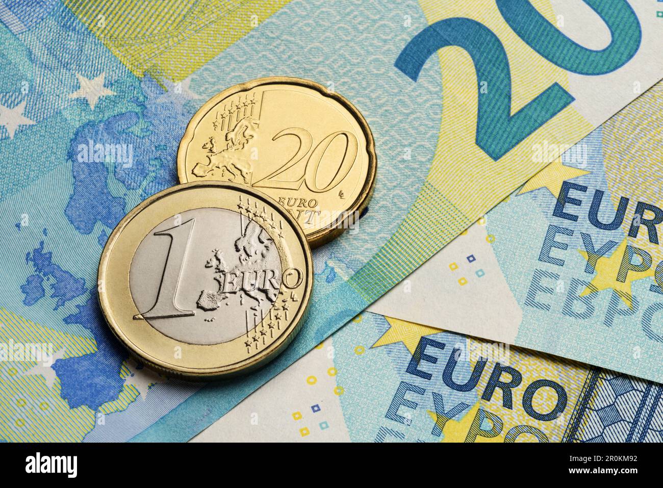 Monete da un euro e da venti centesimi sulle banconote di carta blu. Foto Stock