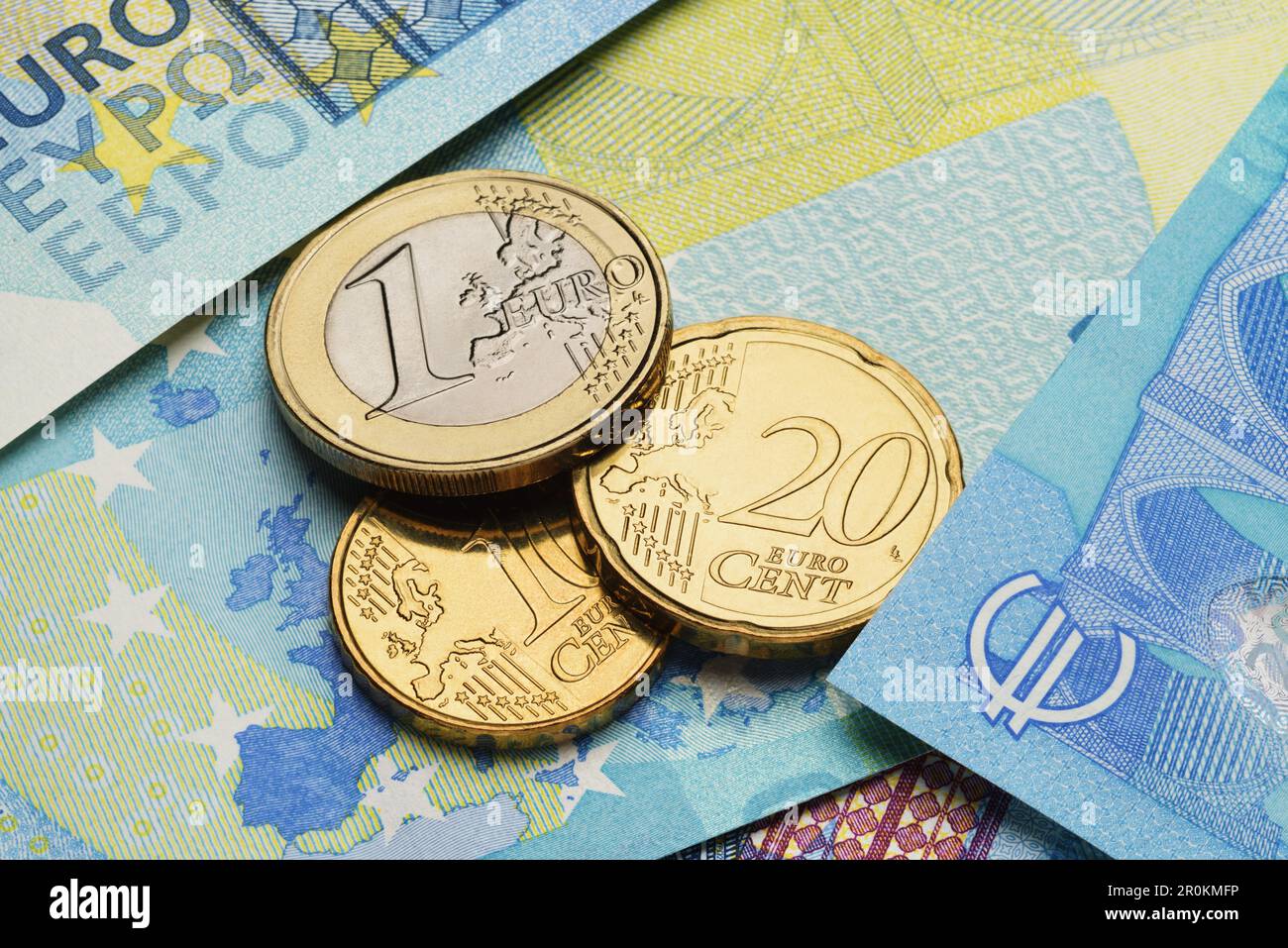 Monete da un centesimo e un euro sulle bollette di carta blu. Foto Stock