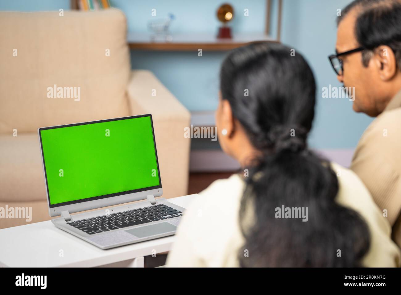 Presa della coppia anziana indiana che prende alla videochiamata sul laptop con schermo verde a casa - concetto di tecnologia, comunicazione e online Foto Stock