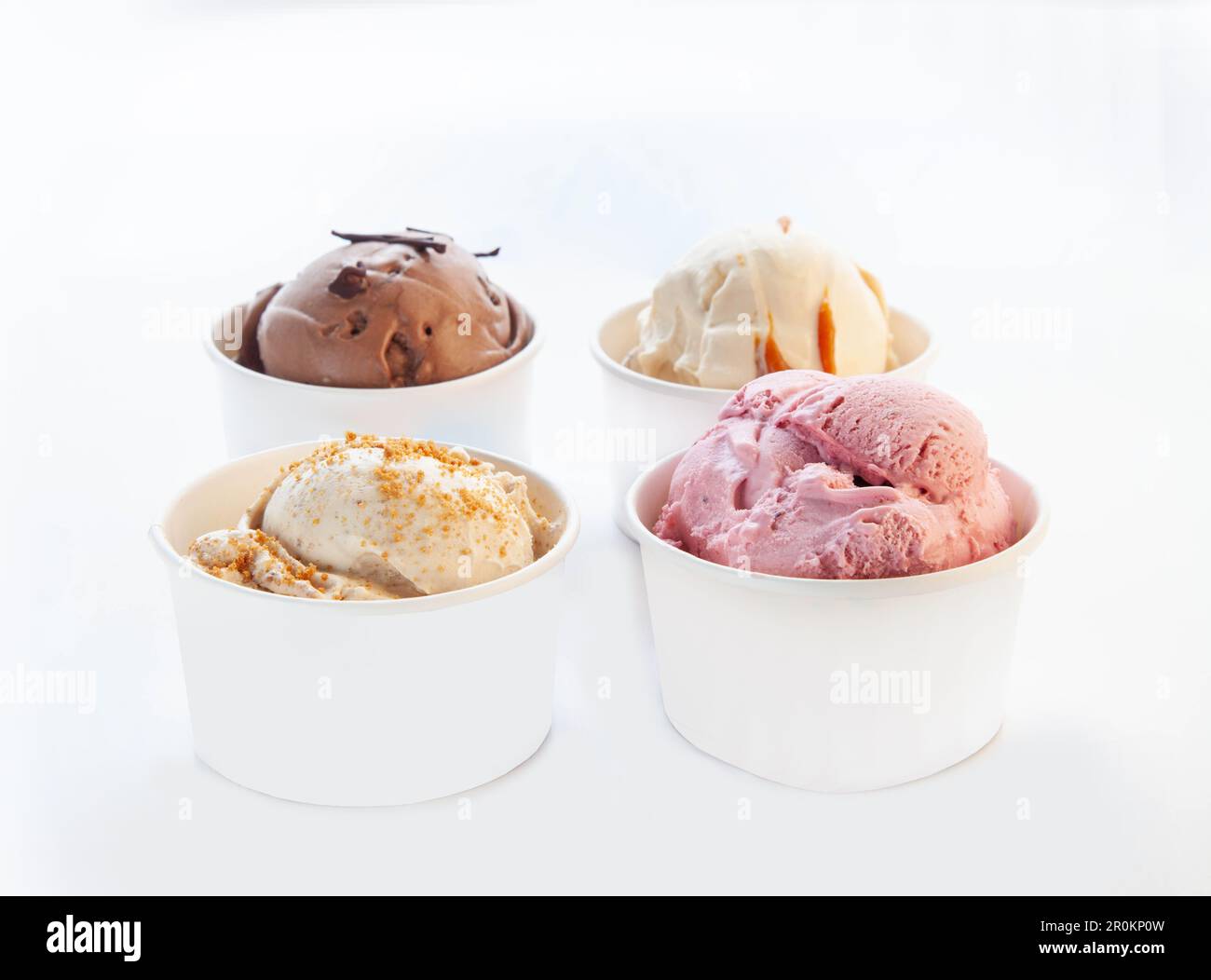 Gelato al cioccolato bianco al caramello alla vaniglia in una tazza di carta senza marchio con cucchiaio di plastica. Foto Stock