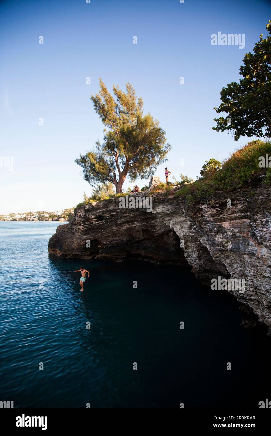 BERMUDA. Parrocchia di Hamilton. Cliff jumping, nuoto fuori da un punto nella Admiralty House Park di Hamilton. Foto Stock