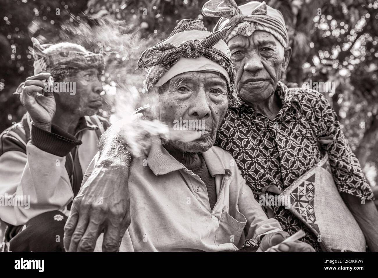 INDONESIA, Flores, 100 anni di sambuco Wilhelmus Etu presenta un fumo con i suoi amici in Kampung Tutubhada villaggio in Rendu Foto Stock