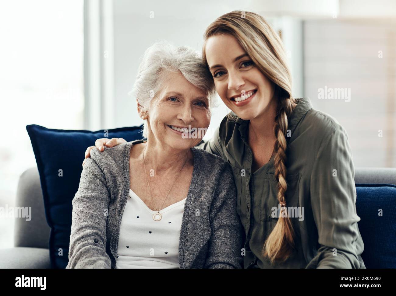 Essere profondamente amati da qualcuno ti dà forza. una donna anziana e la figlia adulta che siedono insieme a casa. Foto Stock