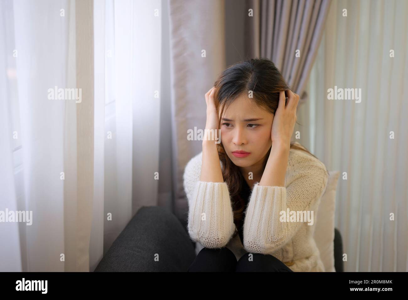 Bella donna con triste emozione sedersi sul divano. Concetto di vita e di emozione negativa. Foto Stock