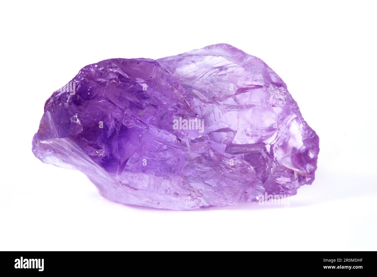 Un pepite di ametista grezzo su uno sfondo bianco. L'Ametista è una varietà di quarzo. L'ametista è di colore viola. E' una pietra semi-preziosa. Foto Stock