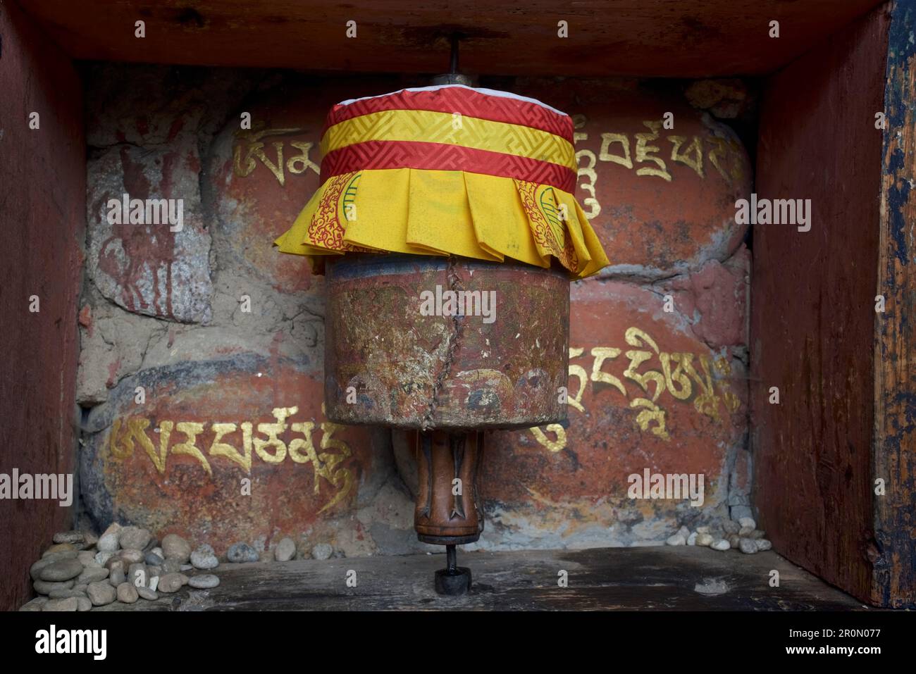 Ruota di preghiera con il mantra Om mani Padme Hum nelle Scritture tibetane nella Valle di Bumthang, Bhutan, Himalaya, Asia Foto Stock