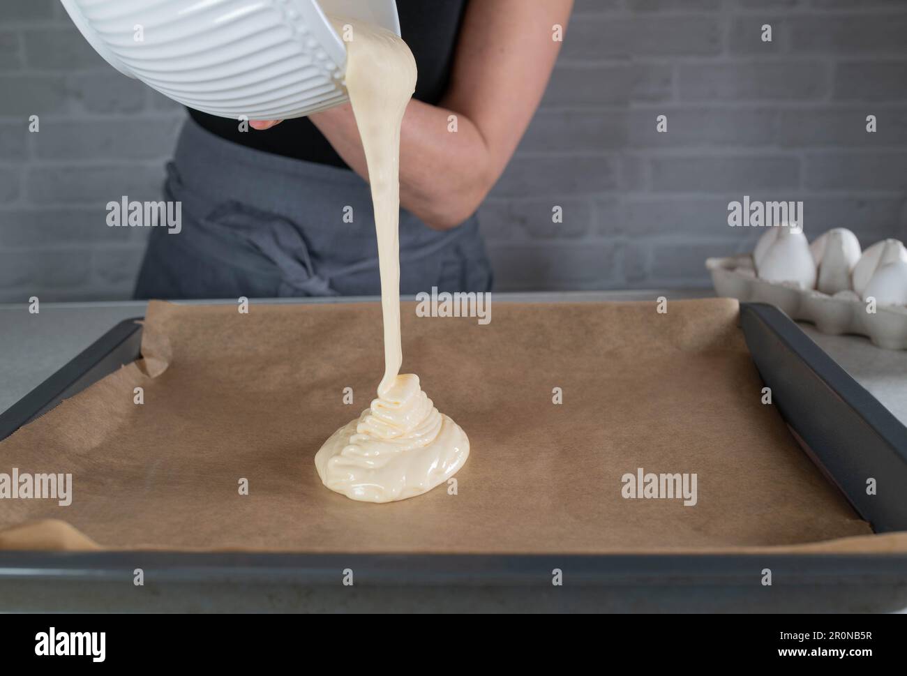 Versare l'impasto su una teglia da forno. Blocca movimento Foto Stock