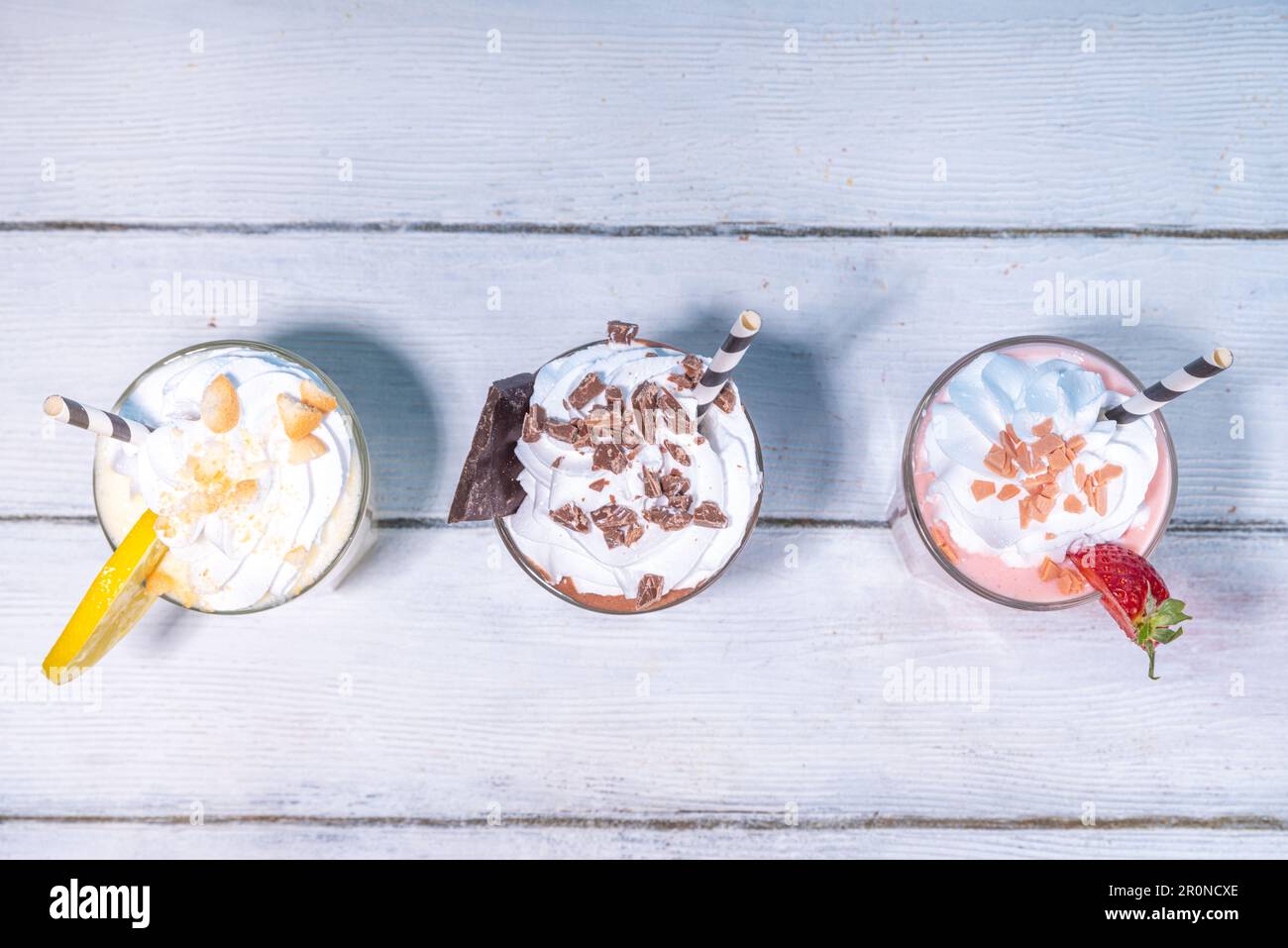 Set di frullati rinfrescanti o frullati estivi dal gusto classico e delizioso - limone alla vaniglia, fragola, cioccolato, con panna montata e condimenti, Foto Stock