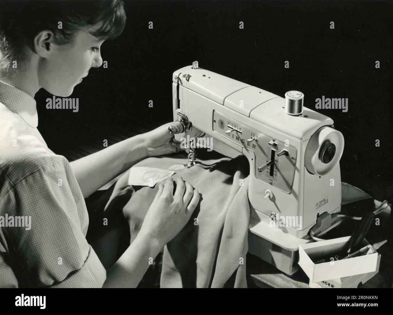 Donna che lavora con una macchina da cucire Singer 338 all'Ideal Home Exhibition, Londra UK 1966 Foto Stock