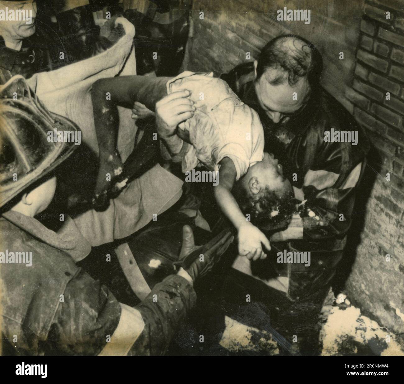 Estrarre il corpo di un bambino dalle macerie dopo il terremoto, 1960s Foto Stock