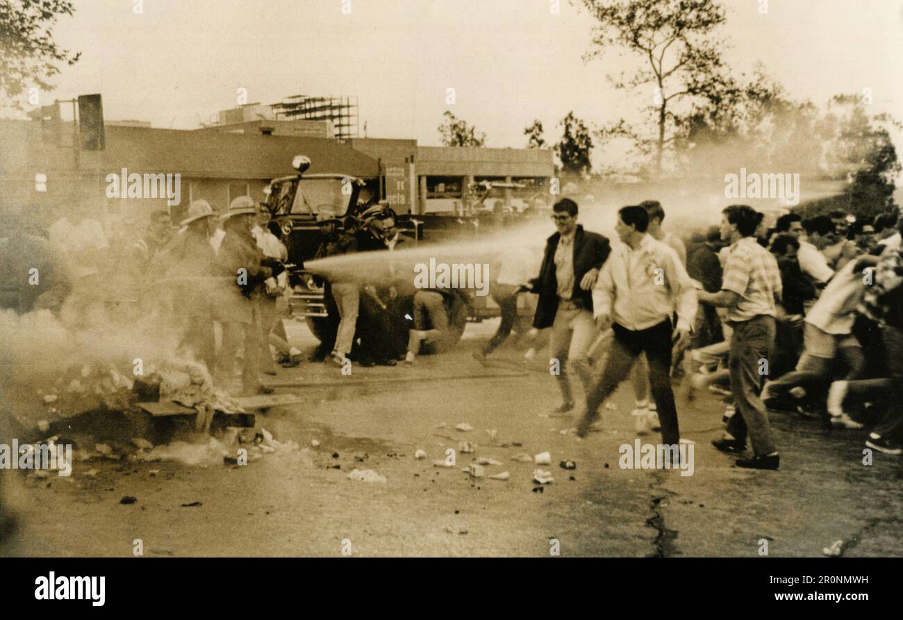 I vigili del fuoco spruzzano i giovani con idrante antincendio, 1960s Foto Stock