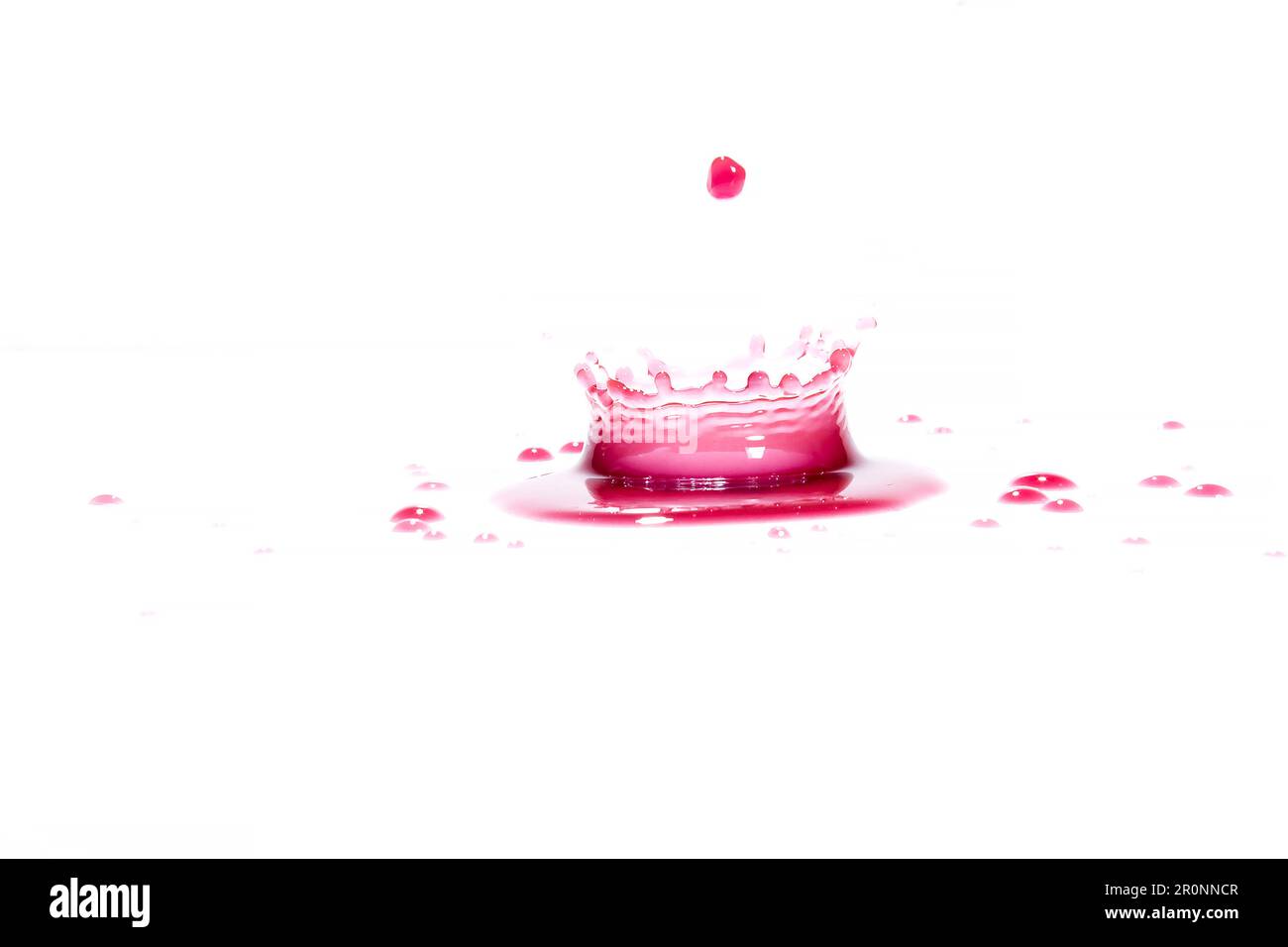 Spruzzi di acqua rossa su sfondo bianco, fotografia. Spruzzi d'acqua rossi. Foto Stock