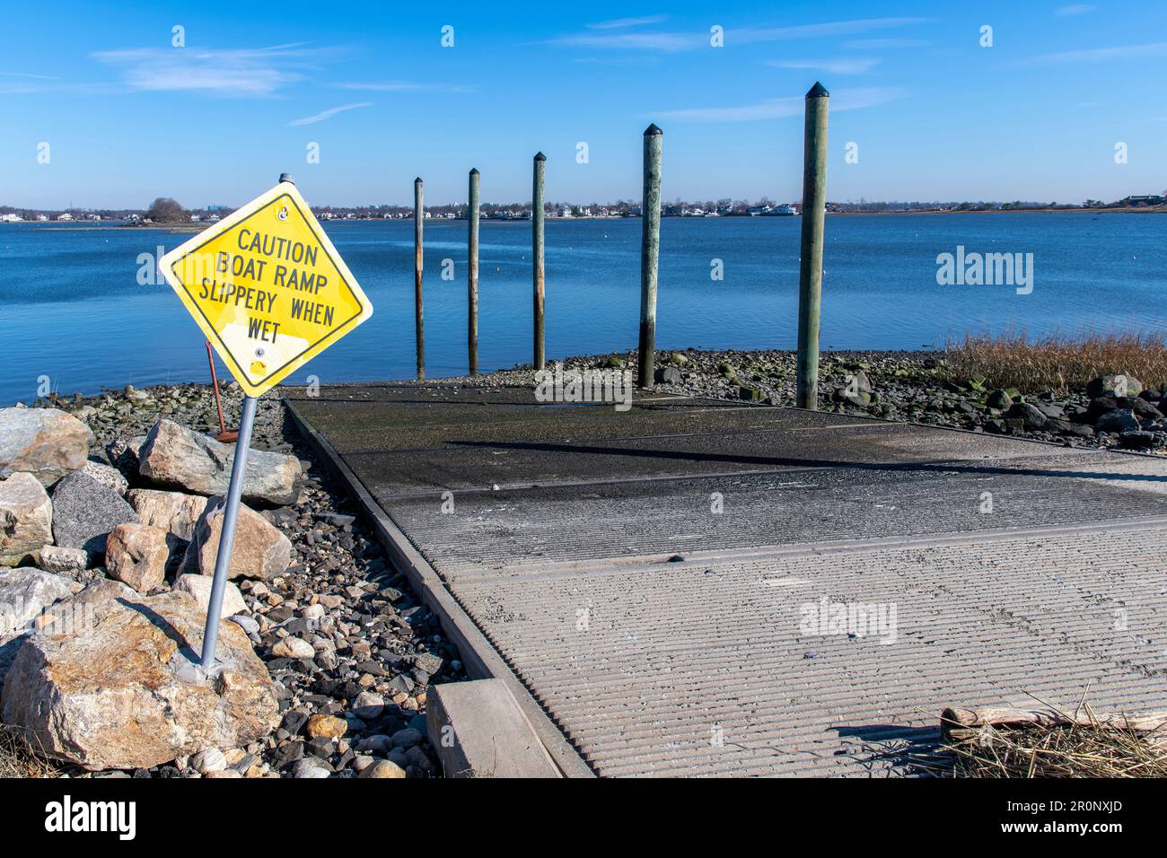 Vista di una rampa di accesso per imbarcazioni in cemento a Greenwich Cove, Tod’s Point, Greenwich, CT, USA con segnale di avvertimento per superfici scivolose Foto Stock
