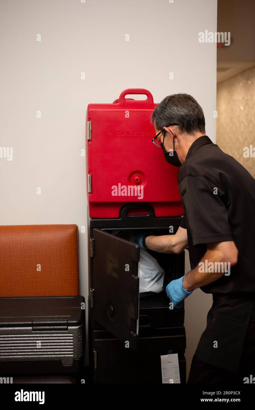 Los Angeles, California, Stati Uniti - 08-24-2021: Una vista di un dipendente del ristorante che effettua un ordine da portare in un armadietto alimentare Cambro. Foto Stock