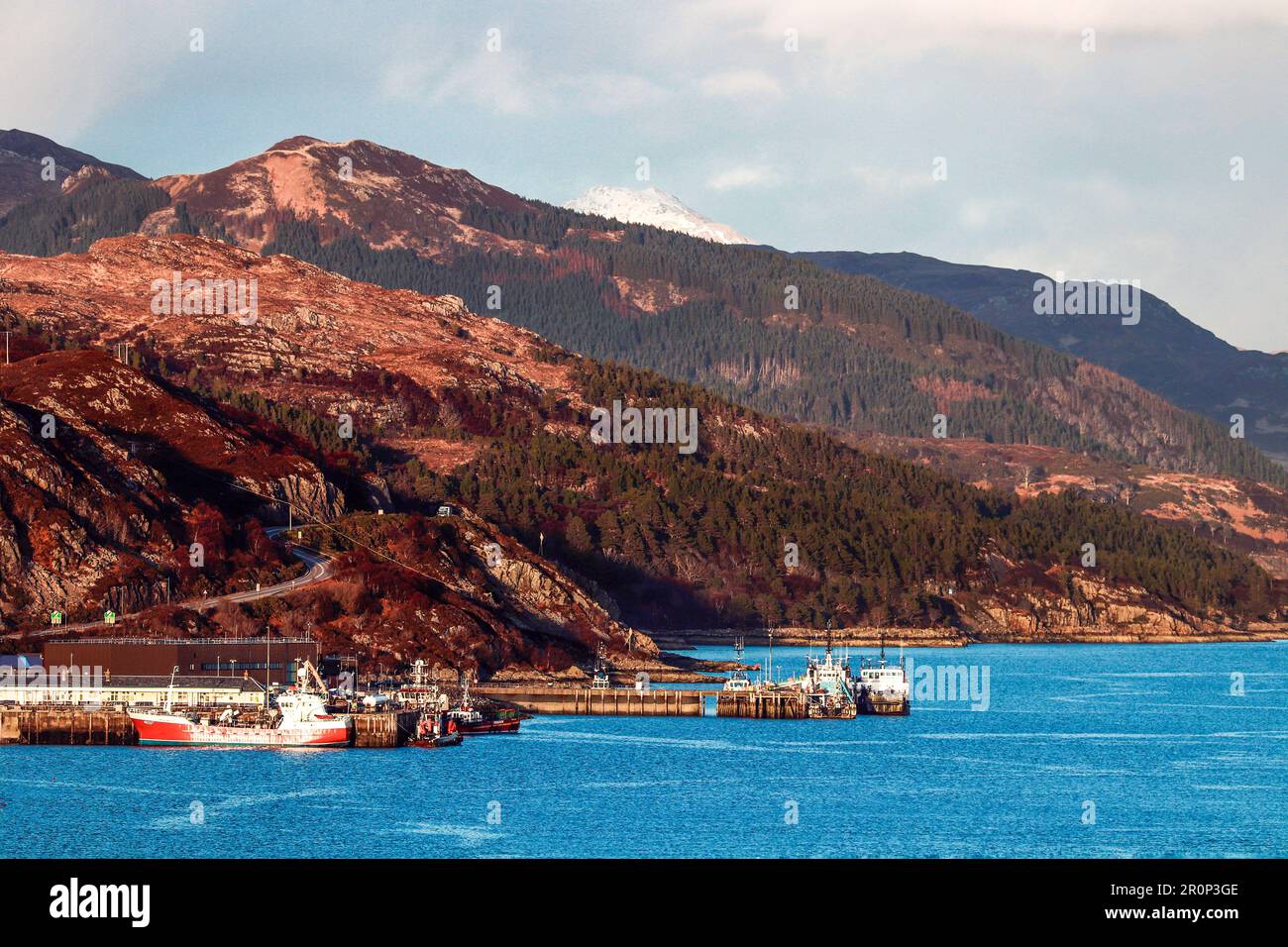 Una vista aerea di grandi imbarcazioni ormeggiate lungo la costa di una maestosa montagna a Kyle di Lochalsh, Scozia, Regno Unito Foto Stock