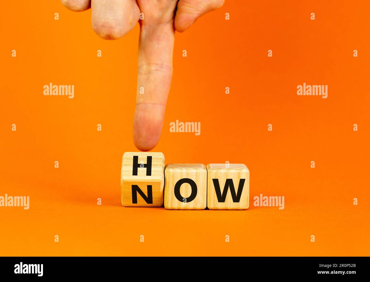 Sapere come simbolo. Uomo d'affari gira cubi di legno e cambia la parola come sapere. Bella tavola arancione sfondo arancione. Spazio di copia. Business e k Foto Stock