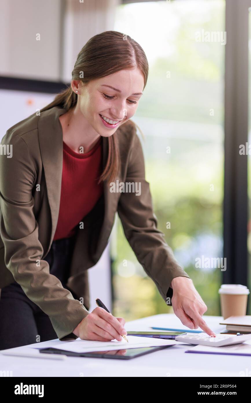Concetto di business Office donna che lavora, Businesswoman sorriso mentre lavorando sul suo piano di invesment con l'analisi di documenti e di business investment gr Foto Stock