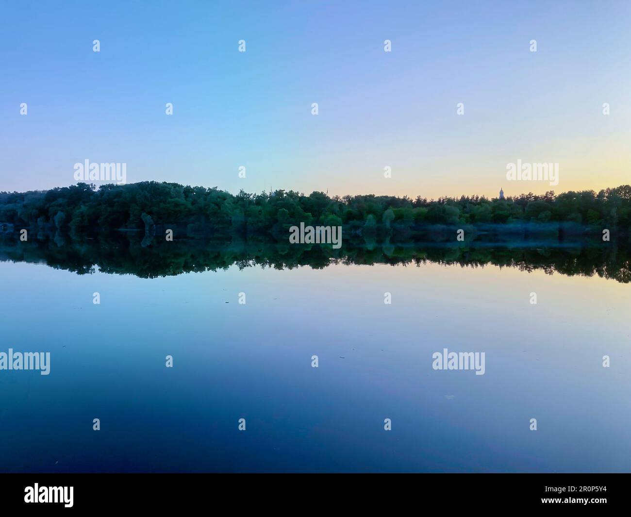 Fiume Biebrza al tramonto, riflesso nell'acqua, sagome di alberi che si riflettono nella calma acqua del fiume. alberi riflessi nel fiume calmo a. Foto Stock