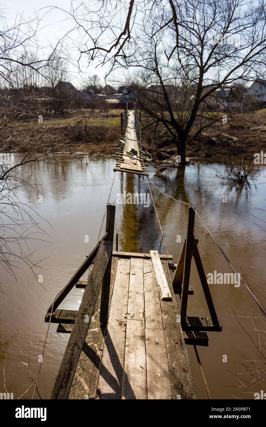 Riparazione di un ponte in legno su un ponte sospeso attraverso un fiume in campagna Foto Stock