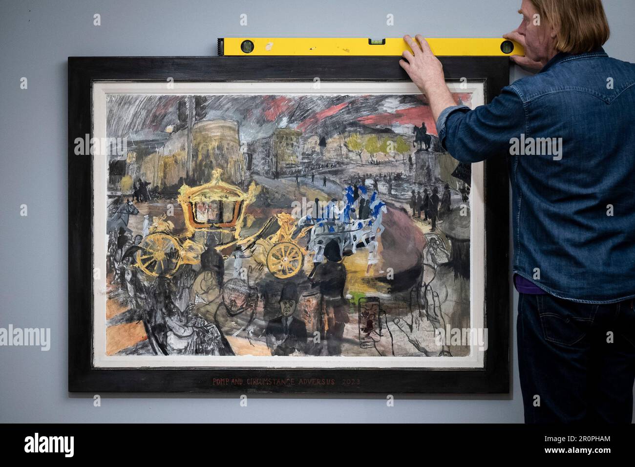 Ritrasmettendo il nome degli artisti correttori da Llewelyn a Llywelyn 'pompa e circostanza Adversus' dell'artista contemporaneo britannico, Dan Llywelyn Hall è installato nella Guildhall Art Gallery di Londra. L'illustrazione mostra che il Gold state Coach è tirato da cavalli grigi Windsor rivestiti in blu, mentre i telefoni sono tenuti in mano per scattare fotografie e video dello spettacolo che si muove oltre. Il sig. Llywelyn Hall è stato posizionato a Trafalgar Square fuori dalla National Gallery il sabato, lavorando per tutto il giorno per catturare scene della processione da Buckingham Palace all'Abbazia di Westminster. Data foto: Martedì Foto Stock