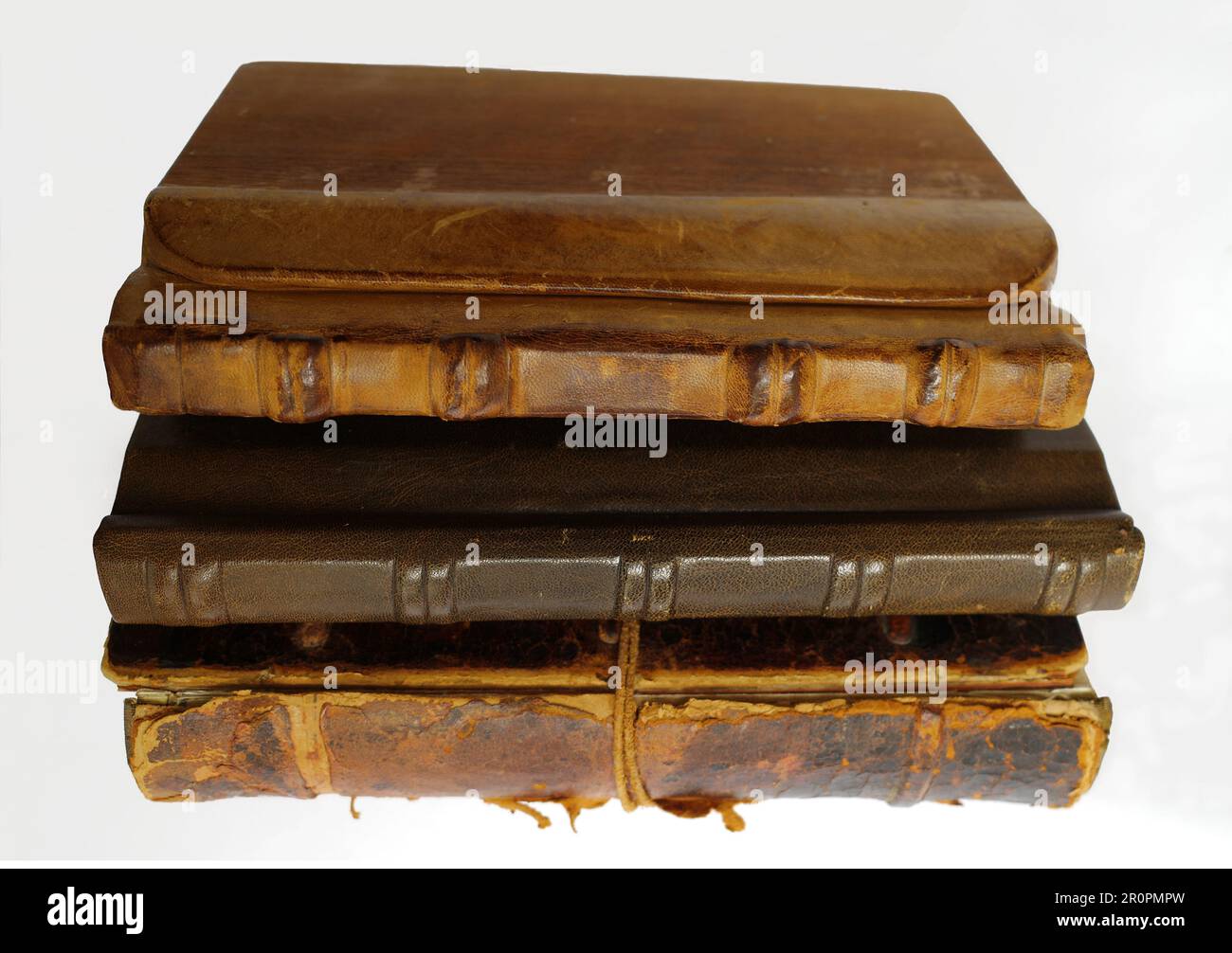 Raccolta di tre vecchi libri su sfondo bianco. La copertina di questi libri è in pelle o cuoio e legno. Foto Stock