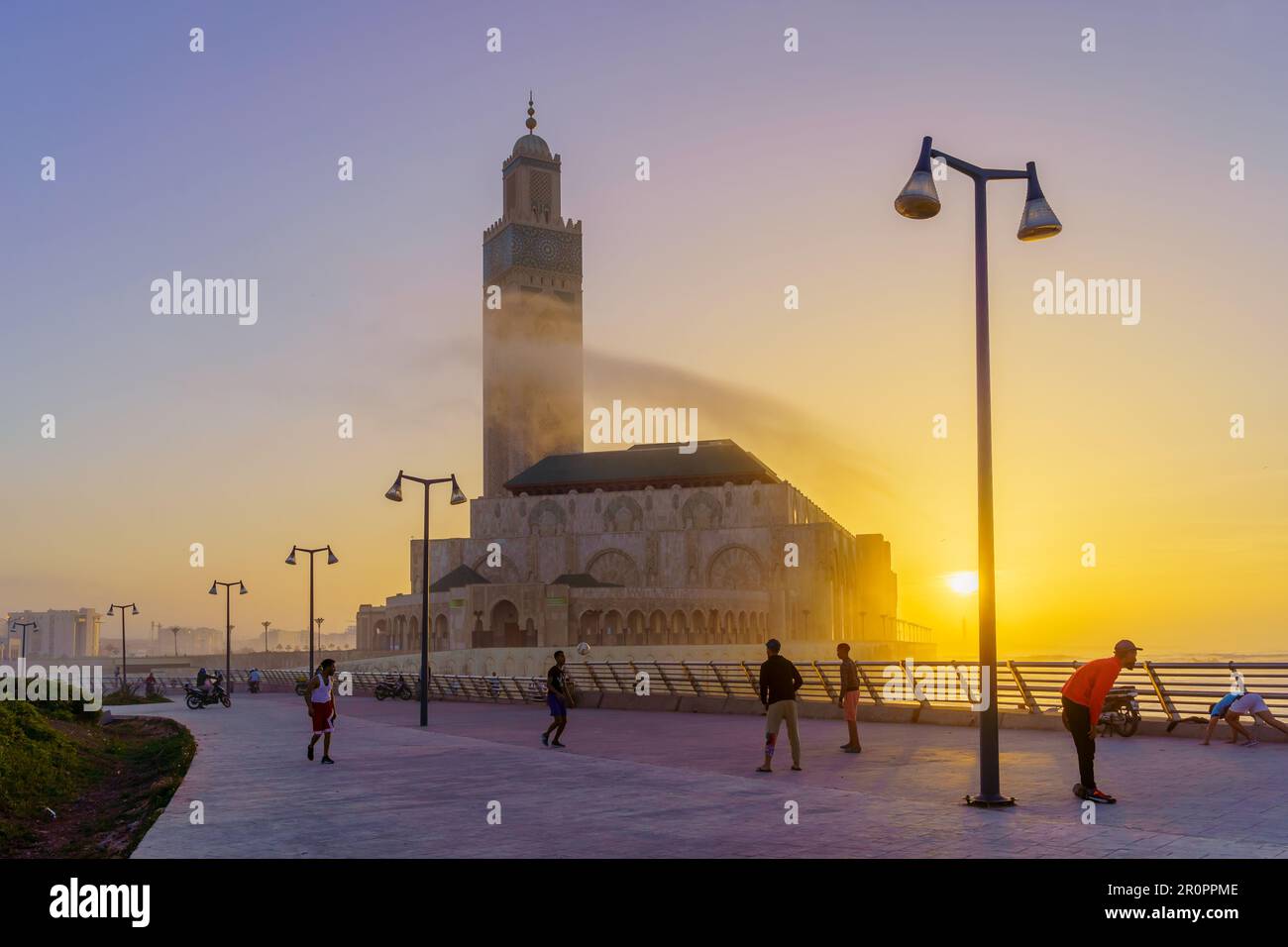 Casablanca, Marocco - 29 marzo 2023: Tramonto scena della moschea di Hassan  II, con gli abitanti del luogo che giocano a calcio, la passeggiata, e El  Hank Lighthouse, a CA Foto stock - Alamy