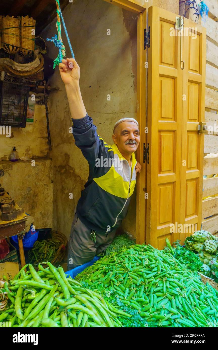 Fes, Marocco - 31 marzo 2023: Vista di un vicolo con un venditore e la sua stalla, nella vecchia Medina di Fes, Marocco Foto Stock