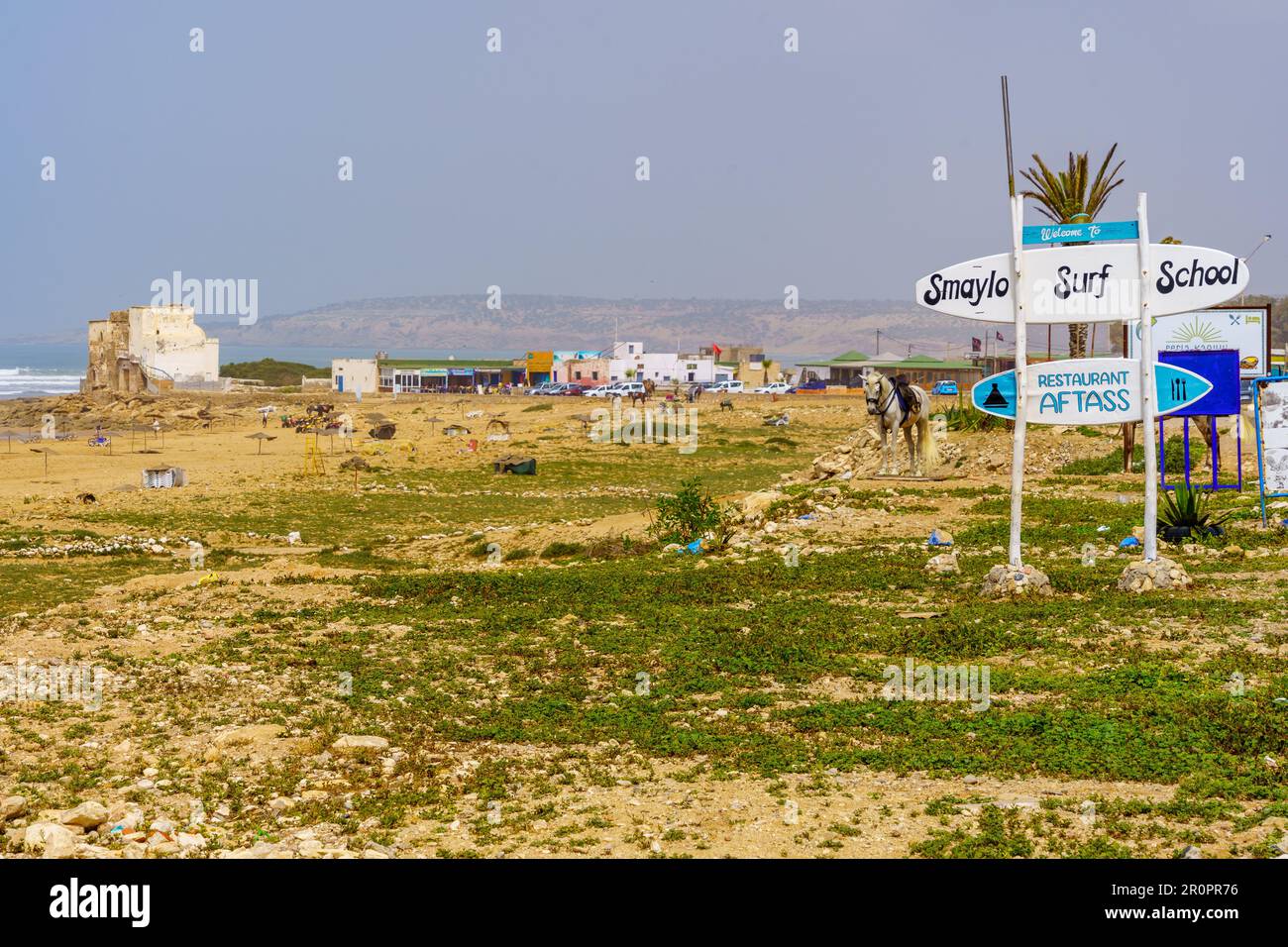 Sidi Kaouki, Marocco - 07 aprile 2023: Vista della località balneare di Sidi Kaouki, con vari segni e un cavallo. Marocco Foto Stock