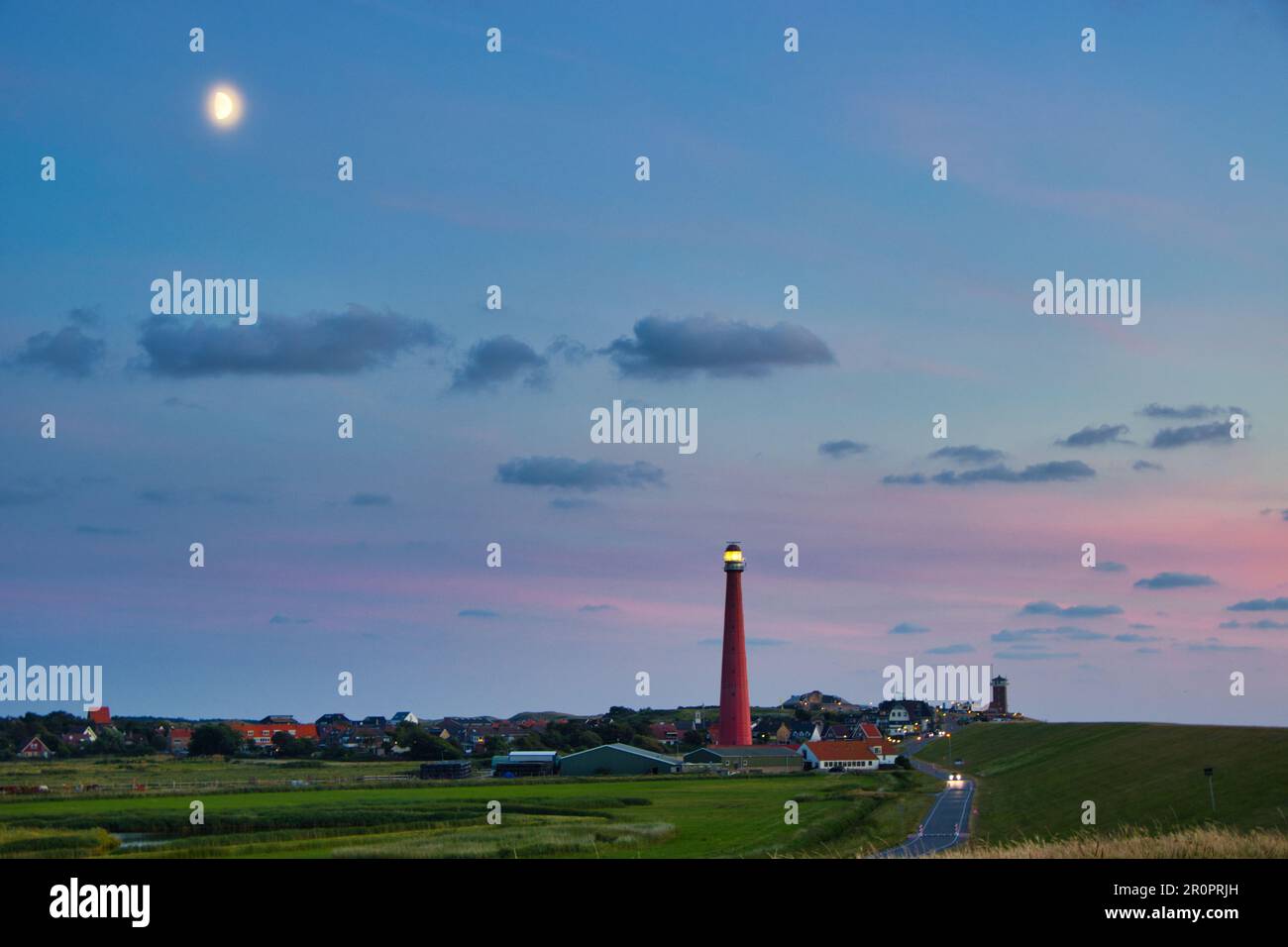 Sulla diga con vista sul faro di Den Helder (luna nel cielo) Foto Stock