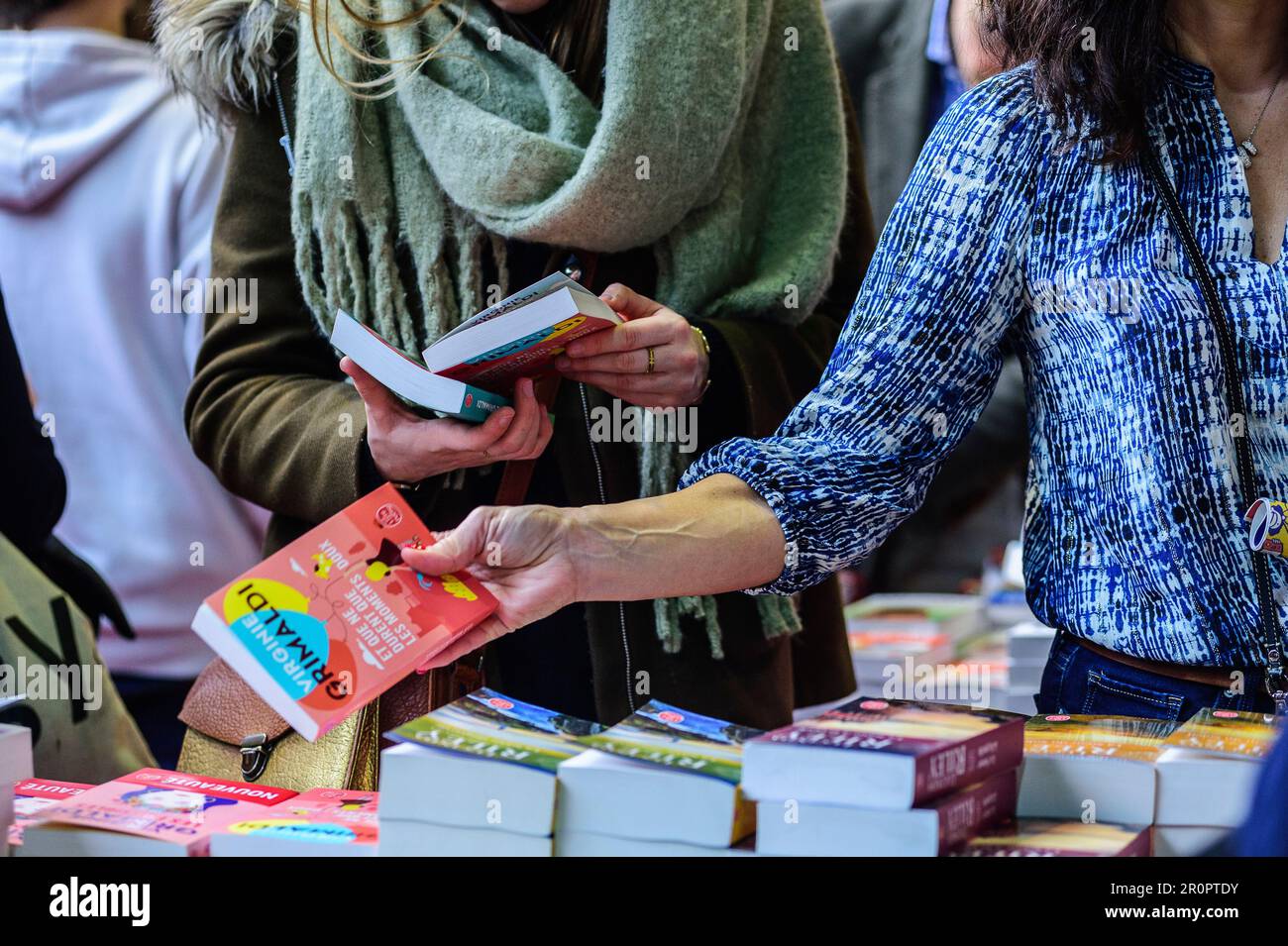 Foire du Livre de Bruxelles les gens se pressent autour des presentoirs 2023 Choisir un livre | Bruxelles Books fair 2023 - raccolta di un libro Foto Stock