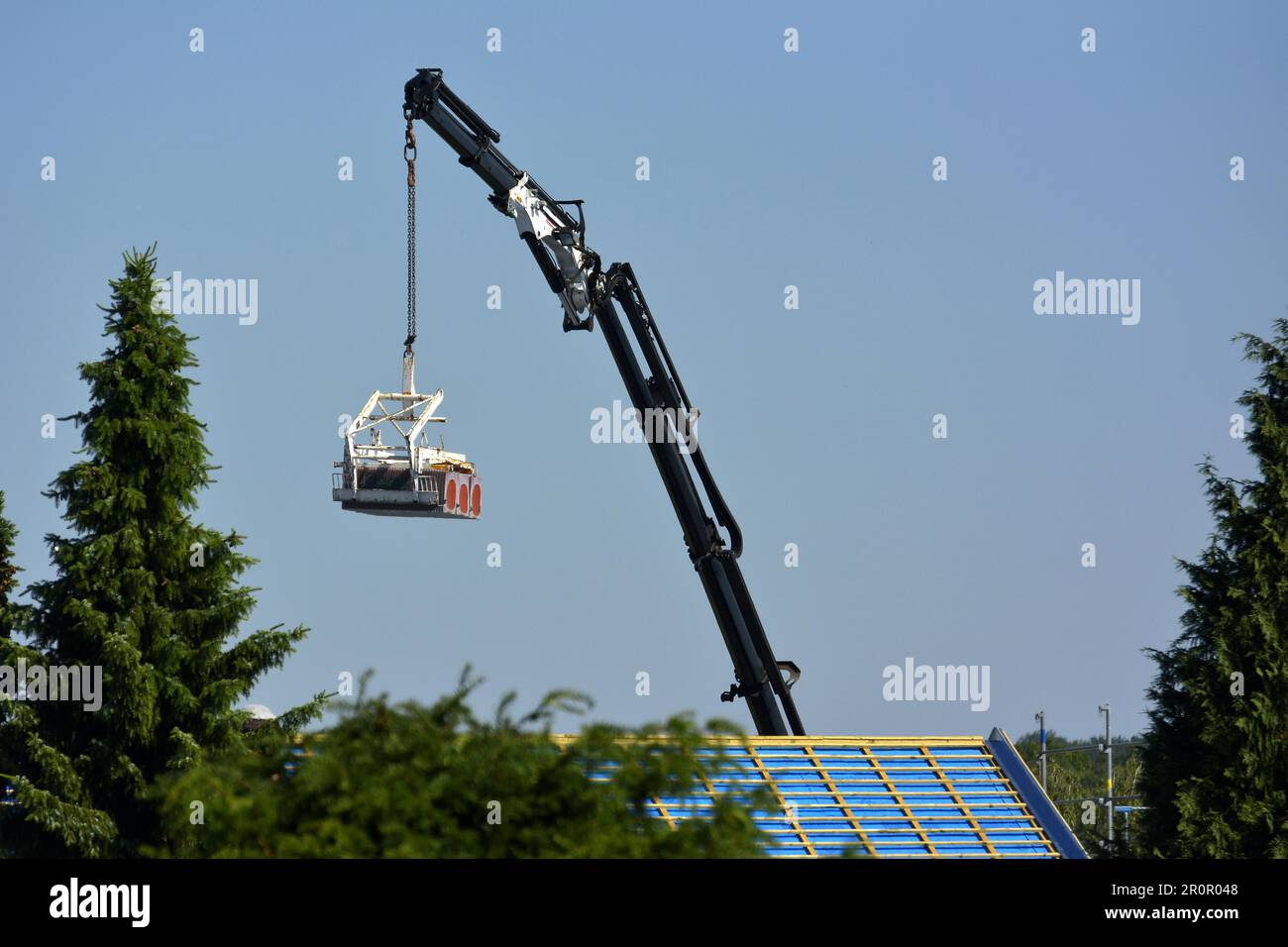 Gru montata su autocarro sul tetto della casa con nuove piastrelle Foto Stock