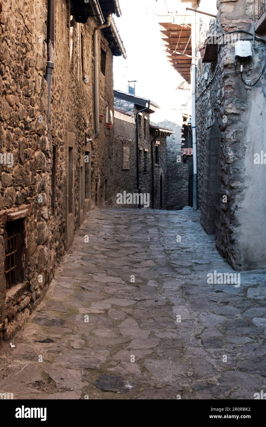 Strada lastricata con pietra di ciottoli in un villaggio rurale con un edificio fatto di vecchie pietre a Bellver de Cerdanya Foto Stock