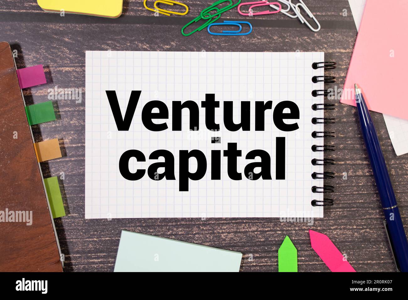 VC simbolo di abbraviazione del capitale di rischio. Concetto parole VC venture capital su nota bianca. Penna metallica. Bollette in dollari. Bellissimo sfondo bianco. Copia s. Foto Stock