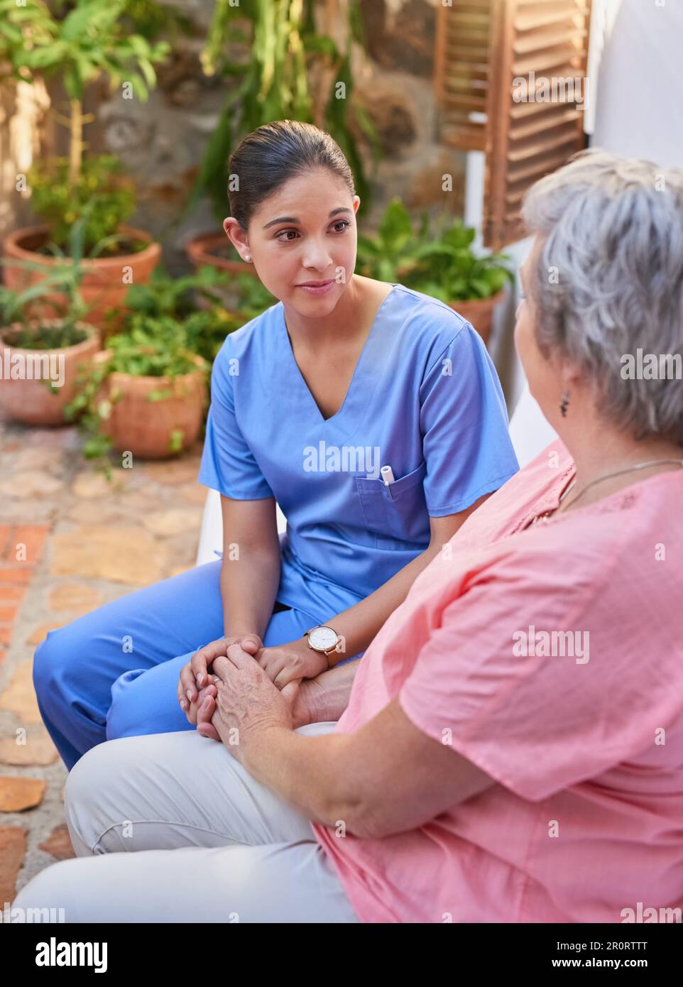 Invia un IM qui per ascoltare se hai mai bisogno di scaricare. un operatore sanitario che chiacchiera con un paziente anziano all'esterno. Foto Stock