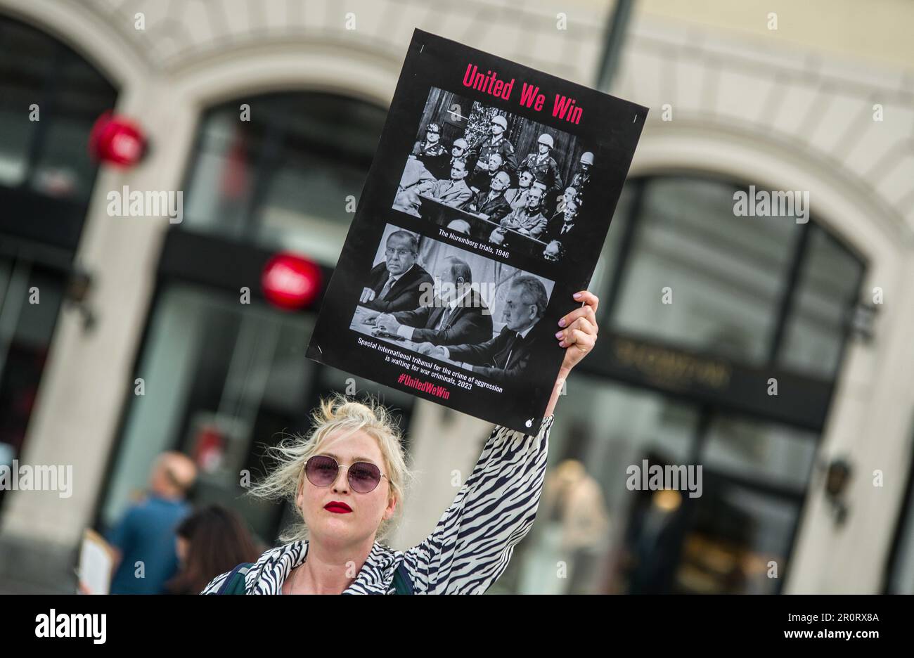 9 maggio 2023, Monaco, Baviera, Germania: Una donna Ucraina ha un segno con immagini contro la Russia. In coincidenza con le celebrazioni della Giornata Mondiale della Vittoria, Monaco di Baviera ha visto un'altra demo del reggimento immortale che è stata questa volta guidata da Amid Saidi, che ha organizzato la demo putinista nel 2022. Originariamente concepito dai giornalisti russi Sergei Kolotovkin, Sergei Lapenkov e Igor Dmitriev, per avere commemorazioni non militarizzate di coloro che hanno combattuto nella seconda guerra mondiale, il reggimento immortale (Ger: Unsterbliches Regiment) è stato visto dal 2015 come parte della guerra ibrida del regime Putin e delle offese espansionistiche nella WO Foto Stock 9 maggio 2023, Monaco, Baviera, Germania: Una donna Ucraina ha un segno con immagini contro la Russia. In coincidenza con le celebrazioni della Giornata Mondiale della Vittoria, Monaco di Baviera ha visto un'altra demo del reggimento immortale che è stata questa volta guidata da Amid Saidi, che ha organizzato la demo putinista nel 2022. Originariamente concepito dai giornalisti russi Sergei Kolotovkin, Sergei Lapenkov e Igor Dmitriev, per avere commemorazioni non militarizzate di coloro che hanno combattuto nella seconda guerra mondiale, il reggimento immortale (Ger: Unsterbliches Regiment) è stato visto dal 2015 come parte della guerra ibrida del regime Putin e delle offese espansionistiche nella WO Foto Stock