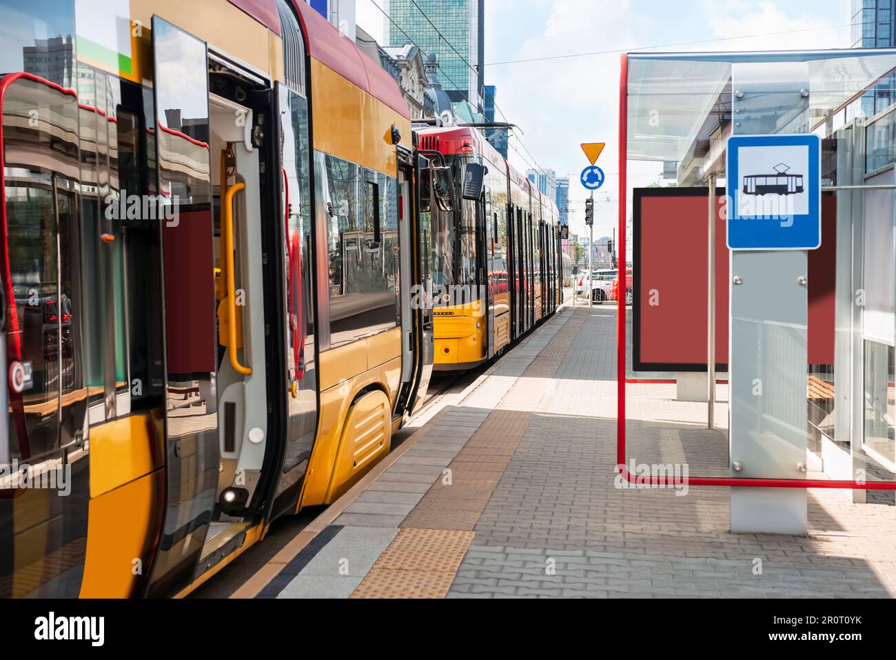 Tram moderni vicino alla fermata del tram nelle giornate di sole. Trasporti pubblici Foto Stock